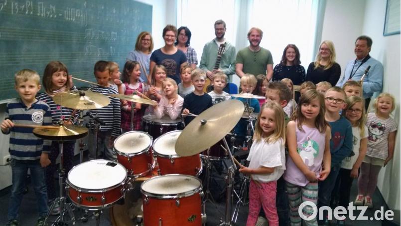 Die Leiterin des Kindergartens „St. Martin“, Theresa Uhl (stehend, Zweite von links) ist wie die Kids von den verschiedenen Instrumenten begeistert. Flugs schwingt sie sich aufs Drumset und zeigt den Kleinen ihre vielfältigen musikalischen Fähigkeiten. Bild: kwl