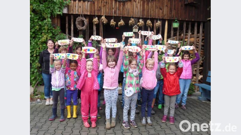 Stolz präsentierten die Kinder die mit Kartoffelstempeln gestalteten Schlampermäppchen. Mit auf dem Bild Vorstandsmitglied Monika Stock (links). Bild: njn