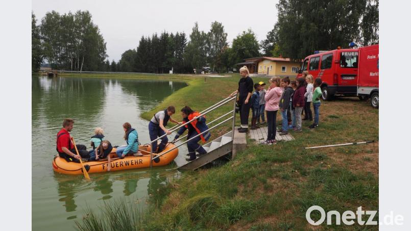 Die Mädchen und Buben warten geduldig auf das Anlegen des Schlauchbootes. Bild: gz