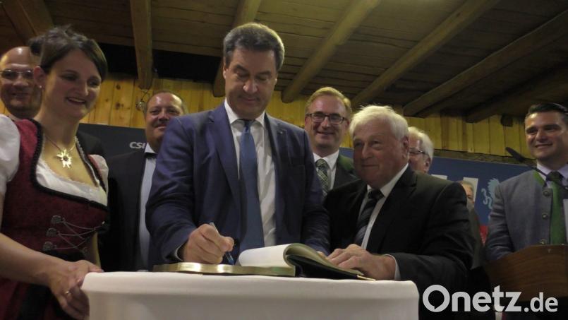 Zum Abschluss seines Besuches in Guteneck trug sich der bayerische Ministerpräsident Markus Söder ins Goldene Buch der Gemeinde ein, das Bürgermeister Johann Wilhelm (vorne rechts) mit in den Gutsstadel des Schlosses gebracht hatte. Bild: exb