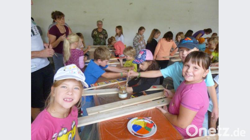 Die Kinder haben viel Spaß beim Bemalen ihrer Zaunlatten. Bild: rgl