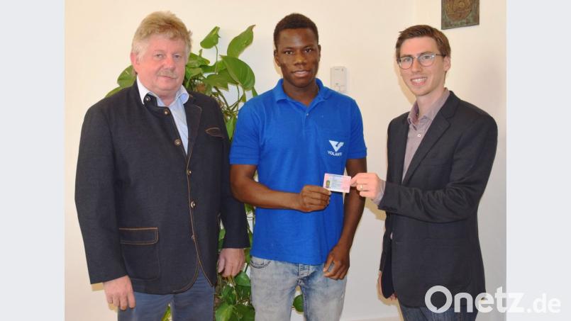 Erich Sperber (links) freut sich, dass sein Betrieb Maba Kante (Mitte) weiter beschäftigen kann. Michael Schiller von der Ausländerbehörde des Landratsamtes (rechts) überreicht ihm die allererste 3+2-Aufenthaltsgestattung im Landkreis. Bild: exb