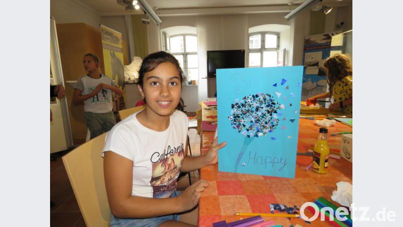 Die 11-jährige Susanne hat eine Pusteblume aus silberglänzendem Mosaik auf hellblauen Karton geklebt. Bild: ubb