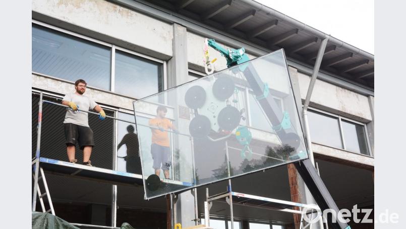 Arbeiter bringen mit einem speziellen Kran die neuen Fensterscheiben in Position. Bild: gsb