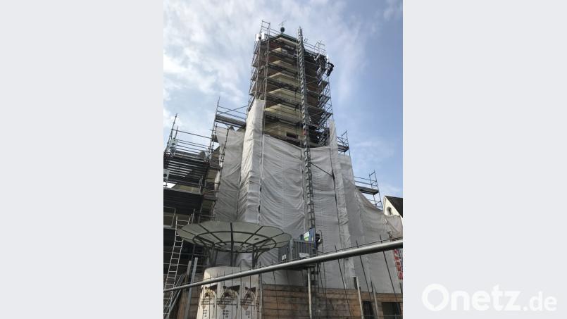 Hoch hinaus geht es für diesen Arbeiter, der am Gerüst des Rathausturms angeseilt ist. Bild: Porsche