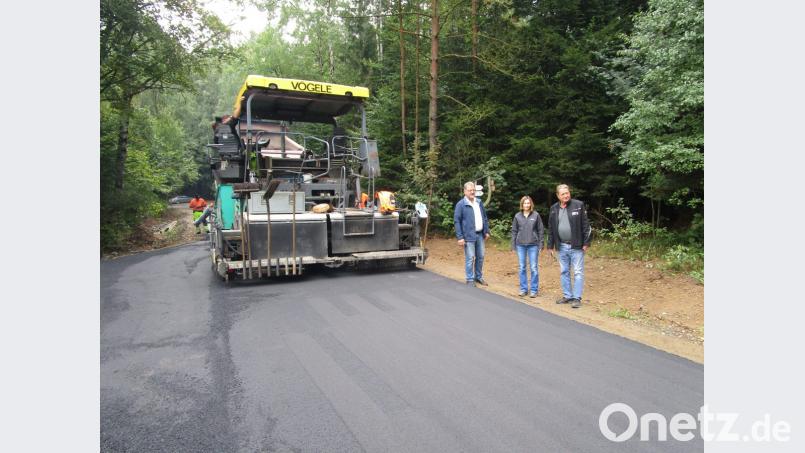 Bürgermeister Johann Maurer, Alexandra Völkl und Werner Kumschier beobachten das Auftragen der Feinschicht Bild: pi