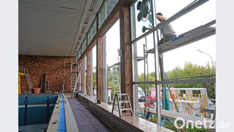 Arbeiter bringen mit einem speziellen Saugkran die neuen Fensterscheiben in Position. Bild: gsb