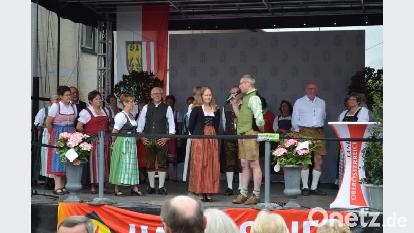 Bürgermeister Hermann Ach stellt bei einem von Martina Kohlmann geführten Interview den Genussort Moosbach vor. Im Hintergrund die OWV-Volkstanzgruppe. Bild: gi