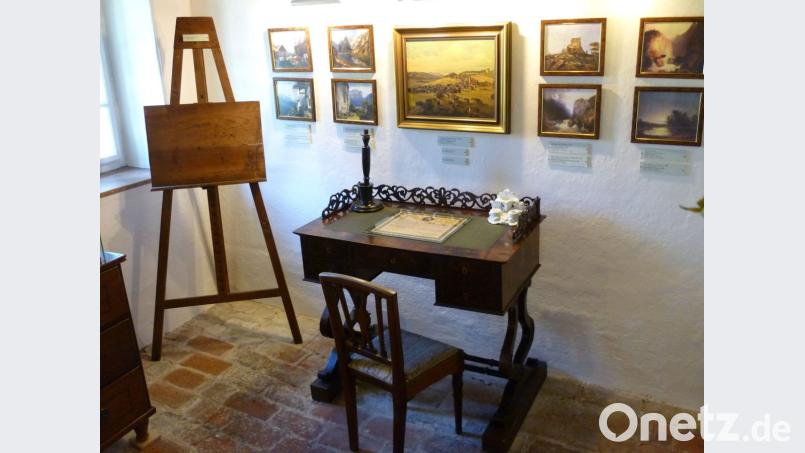 Ein Exponat in Adalbert Stifters Geburtshaus ist sein Schreibtisch, darüber an der Wand Repliken einiger seiner Ölgemälde. Er war sich lange unklar, soll er Maler oder Schriftsteller werden wollte. Bild: Bernhard Setzwein