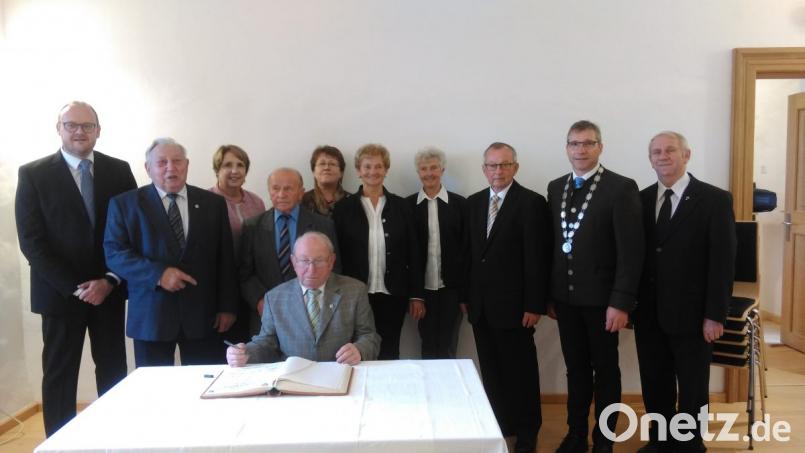 Die "Schlossgeister" tragen sich mit Bürgermeister Hermann Ach, Fördervereinsvorsitzendem Peter Garreiss und anderen Ehrengästen ins Goldene Buch des Markts ein. Bild: ens