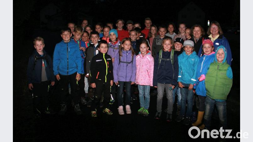 Die Wanderung des Tourismusvereins unter der Leitung von Maria Bauer (Zweite von rechts) führt hinein in die Dunkelheit. 31 Buben und Mädchen gehen auf Gespenstersuche. Bild: wro