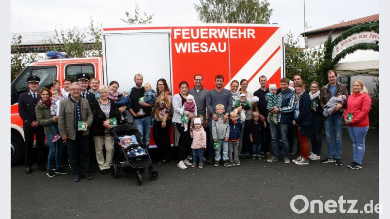 Zusammen mit Bürgermeister Toni Dutz (vorne links) überreichen Feuerwehr-Vorsitzender Manfred Beer (rechts neben Dutz) und Kommandant Thorsten Meiler (links) die lebensrettenden Willkommensgeschenke an die jungen Eltern. Bild: wro