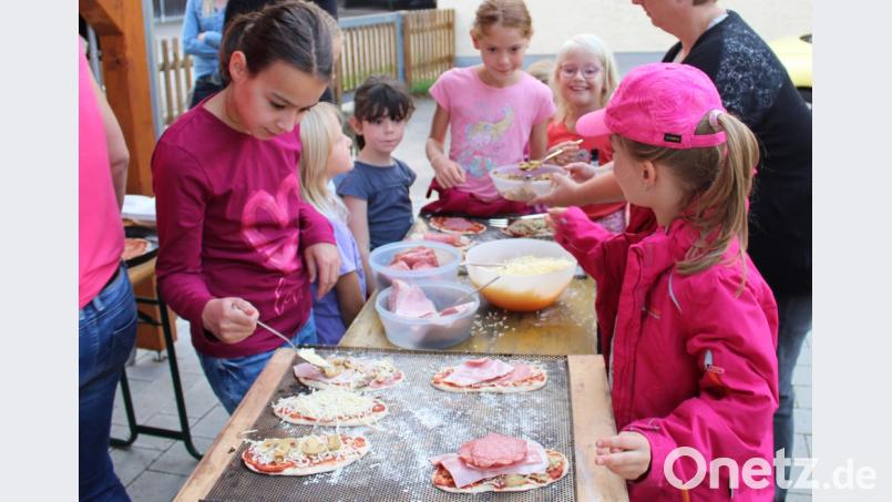 Die Mädchen und Buben dürfen sich ihre Pizzas selbst belegen. Bild: exb