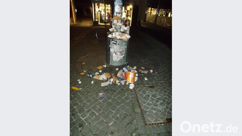 Der Abfalleimer vor dem Rathaus ist voll und der Müll liegt außen herum. Szene von der Luftnacht am Samstag. Bild: Werner Konheiser