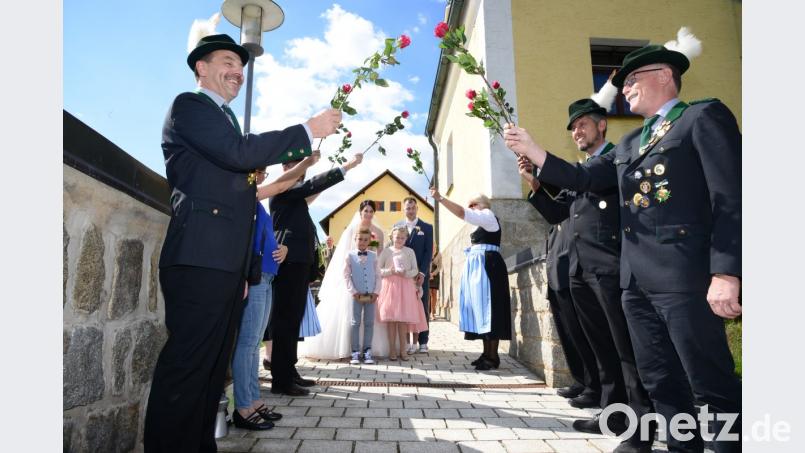 Mit einem Bogen aus Rosen empfangen die Konnersreuther Schützen das Paar. Bild: bey