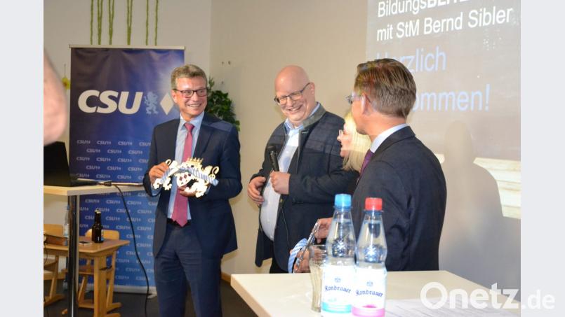Mit einem Löwen aus Metall überrascht Firmenchef Christian Forster (Zweiter von links) Minister Bernd Sibler. Bild: as