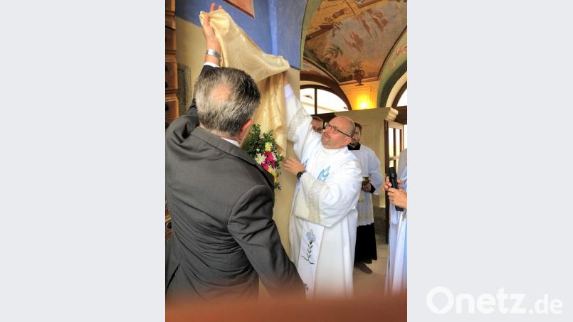 Der Pfarrer von Haid, Miroslav Martis, und Altbürgermeister Johann Walbrunn aus der Partnerstadt Pleystein enthüllen die Gedenktafel für den ehemaligen Dekan Vladimir Born. Bild: tu
