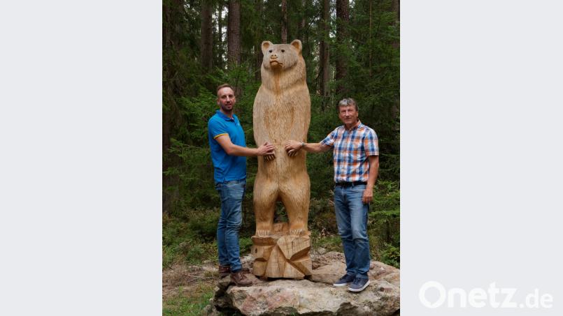Florian Fischer und Gerhard Schneider (von links) Hand in Hand mit dem Bären, den Peter Dietz mit der Motorsäge geschaffen hat. Bild: tr