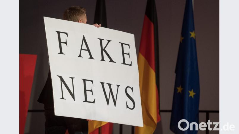 Ein Mann trägt beim politischen Aschermittwoch der baden-württembergischen CDU heuer im Februar ein Schild mit der Aufschrift „Fake News“. Bild: Marijan Murat/dpa