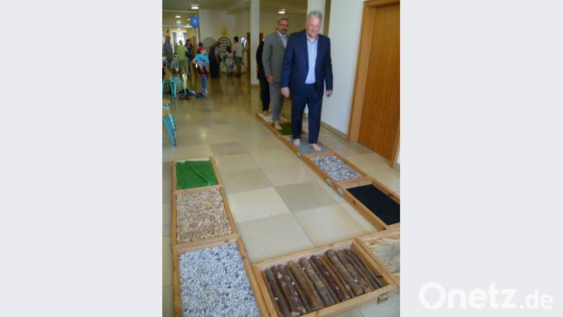 Schuhe und Socken ausgezogen und hinauf auf das mobile Erfahrungsfeld der Sinne. Landrat Richard Reisinger macht’s vor. Bild: Hubert Uschald