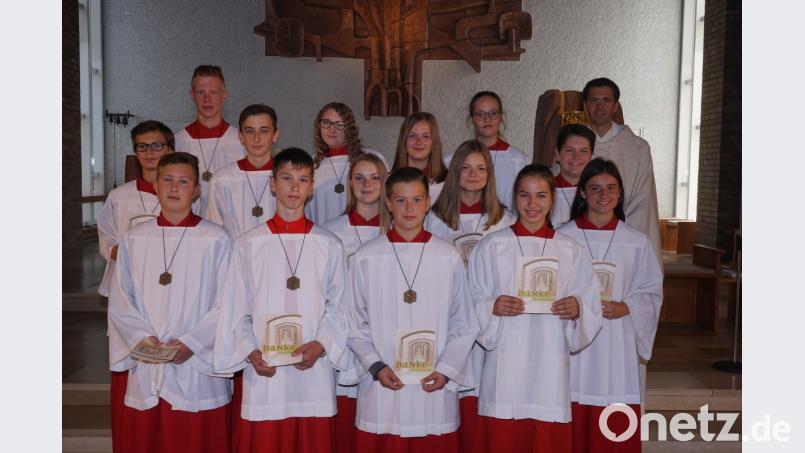 13 Messdiener verabschiedeten Pfarrer Michael Hoch (rechts) und Oberministrant Markus Raab (links hinten) beim Gottesdienst in der Pfarrkirche und bedankten sich bei ihnen mit einer Urkunde. Bild: nib