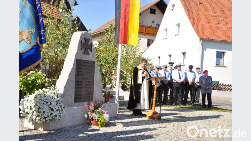 Die Soldaten- und Reservistenkameradschaft Großenschwand feiert 90-jähriges Bestehen. Die Totenehrung hält am Kriegerdenkmal vor der Kapelle Diakon Norbert Hammerl (links, rechts von ihm Mitglieder des Jubelvereins) und Ehrenkreisvorsitzender Dieter Mirus (rechts). Bild: es