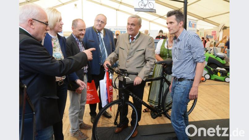 Da schau her, dürften die Besucher der Gewerbeausstellung öfter sagen. Das Angebot ist bunt. Hier greift sich OB Kurt Seggewiß gerade ein E-Bike. Dahinter warten Rasenmäher, Grills, Schmuck und vieles mehr auf die Besucher des Ausstellungszelts. Bild: Gabi Schönberger