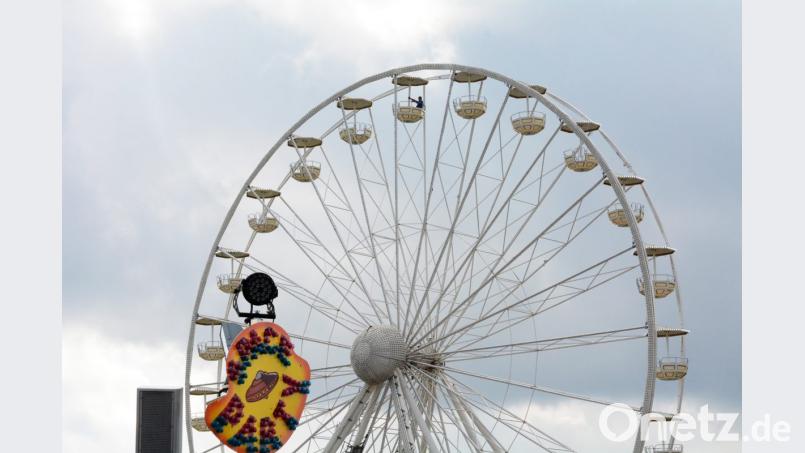 Einer macht&#039;s im Riesenrad vor. Und die Stadt hofft, dass es ihm viele nachmachen und die Fahrgeschäfte bis Dienstagabend gut ausnutzen. Bild: Gabi Schönberger