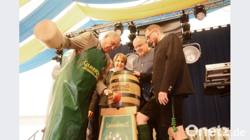 „Da braucht’s Kraft pur“, sagt Oberbürgermeister Kurt Seggewiß (links) und schlägt los. Mit Erfolg. „O’zapft is“, ruft er. Das 120. Volksfest, erstmals unter der Regie der Stadt, ist offiziell eröffnet. Bild: Gabi Schönberger