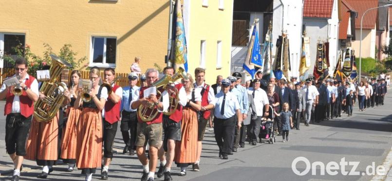 Dem Kirchenzug schließen sich nach dem Jubelverein auch Vereine mit ihren Fahnen an. Bild: es