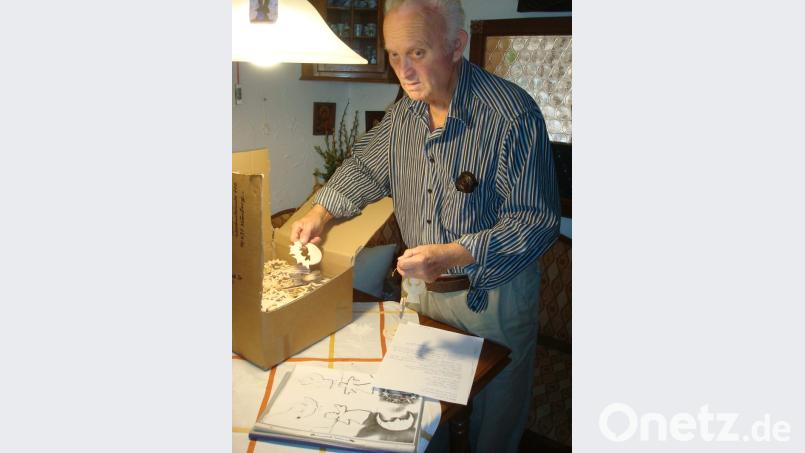 Schnitzer Adolf Gold beim sorgfältigen Verpacken der von ihm in Handarbeit geschaffenen Holzanhänger. Bild: wmr