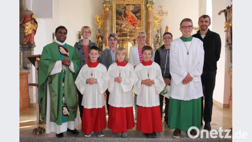Pfarrer Julius Johnrose (links) freut sich, dass Bastian Völkl, Katharina Götz und Christoph Bock (vorne, von links) künftig als Ministranten am Altar stehen werden. Bild: pi