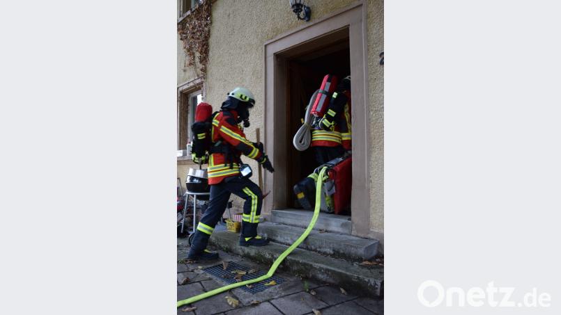 Mit Schlauchtragekorb, geschultertem Schlauchpaket und der Wärmebildkamera geht der erste Atemschutztrupp in das Gebäude vor. Bild: mde