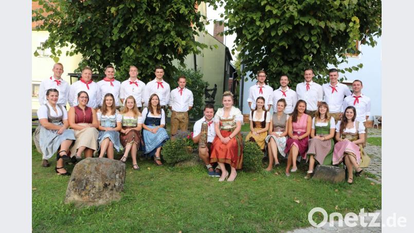 Rund um den Dorfbrunnen postieren sich die Eschenfeldener Kirwapaare zum Gruppenfoto. Bild: exb