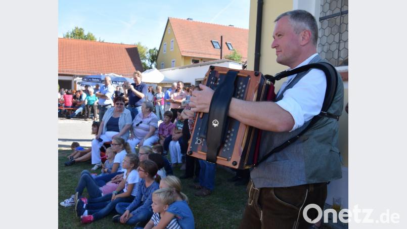 Entspannen bei bestem Wetter im Schatten der Dorfkapelle Mariä Namen hat es schon seit Jahren nicht mehr gegeben - und dazu spielt der Hias mit seiner Diatonischen zünftig auf. Bild: bö
