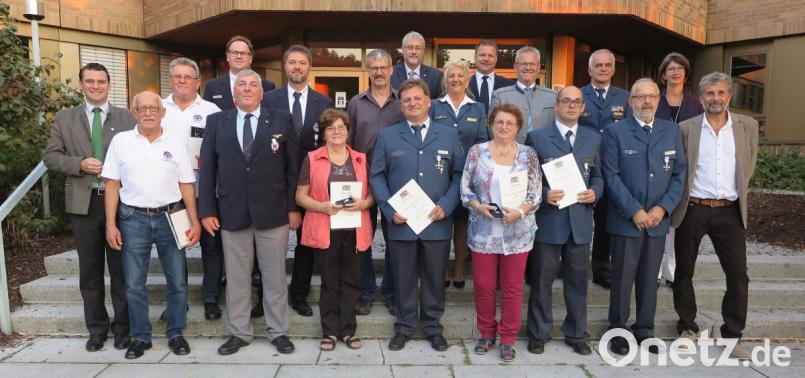Landrat Thomas Ebeling (liinks) verlieh neun langjährigen ehrenamtlichen Helfern von THW und BRK das staatliche Ehrenzeichen. Unser Bild zeigt sie zusammen mit den Ehrengästen. Bild: Hirsch