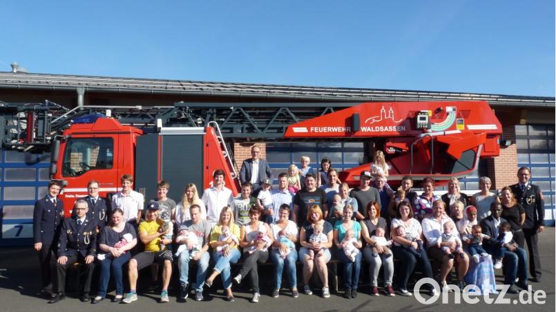 Die Verantwortlichen der Stadt Waldsassen um Bürgermeister Bernd Sommer (hinten, Mitte) und die Kommandanten der örtlichen Feuerwehren (links und rechts) gemeinsam mit den Familien mit Neugeborenen. Bild: flm