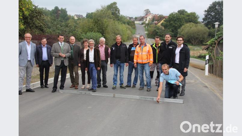 Landrat Thomas Ebeling, die Bürgermeister Walter Schauer und Sonja Meier (ab Drittem von links), Kreisräte sowie Baubeteiligte und Firmenvertreter vergewisserten sich vom erfolgreichen Ausbau der Kreisstraße SAD 47. Bild: frd