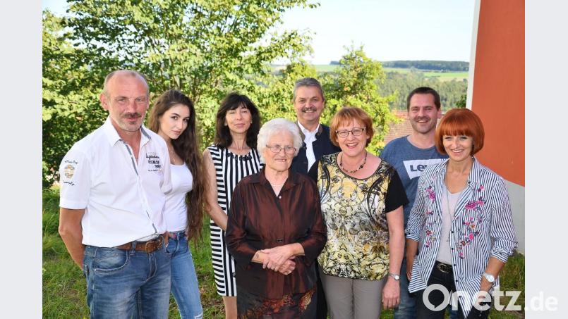 Schwiegertochter Claudia, Sohn Alfred und Tochter Maria (von rechts) sowie Sohn Robert (links) kümmern sich um Theresia Maier (Mitte). Bürgermeister Andreas Wutzlhofer (rechts dahinter) gratuliert. Bild: fjo