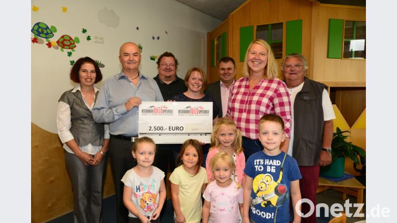 Susanne und Alois Fischer (von links) übergeben Kathrin Götzl, Kinderhaus Heilig Geist (4. von links) und Petra Kunz-Wallerer, Kinderoase St. Emmeram (2. von rechts) einen Spende von 2.500 Euro. Darüber freuen sich Pfarrer Hubert Barteil (3. von links), Kirchenpfleger Bertwin Fleck (rechts) und Bürgermeister Karlheinz Budnik (3. von rechts). Bild: bey