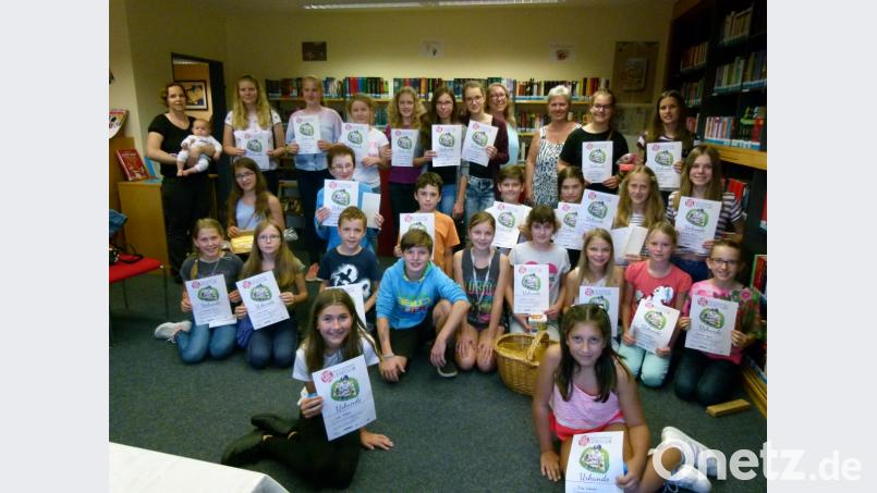 Fleißige Leser versammeln sich in der Stadtbibliothek: Die Teilnehmer am Sommerferienleseclub strahlen angesichts von Erinnerungsurkunden und Preisen. Und das Team um Diplom-Bibliothekarin Petra Danzer (hinten, Vierte von rechts) freut sich über einen Zuwachs bei Teilnehmerzahl und gelesenen Büchern. Bild: rn