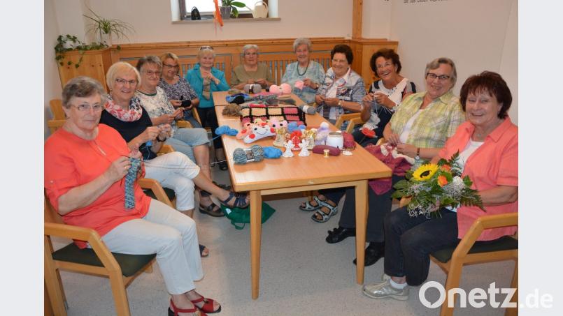 In fröhlicher Runde wird zweimal im Monat gestrickt und gehäkelt: Elf Frauen des Katholischen Frauenbundes Mitterteich bilden derzeit die vereinseigene Bastel- und Handarbeitsgruppe, die vor 30 Jahren von Ursula Thoma (Fünfte von rechts) gegründet wurde. Als Leiterin ist seitdem ihre Tochter Rita Thoma (rechts) aktiv. Frauenbund-Vorsitzende Stilla Schuller (Dritte von rechts) dankte mit einem Blumenstrauß für das Engagement. Bild: jr