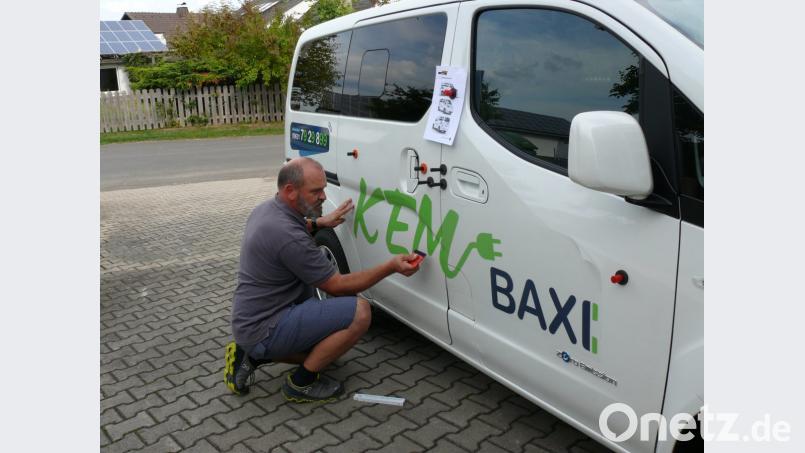 Der Kondrauer Maler- und Lackierermeister Hubert Heinzl beklebt eines der beiden E-Baxis mit dem Schriftzug für Kemnath. Bild: kgg