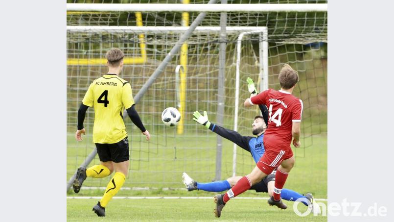 Unhaltbar für den Amberger Torhüter Dominik Haas (rechts hinten) verwandelt der Hahnbacher Fabian Brewitzer zur 1:0-Führung. Der Amberger Innenverteidiger Mario Schmien (links) kam zu spät und konnte nicht mehr rettend eingreifen. Bild: Hubert Ziegler