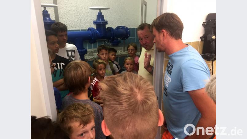 Wasserwart Fabian Utner erklärt den Teilnehmern der Radtour vor Ort, was sich im Pumphäuschen am Katzenbühl abspielt. Bis zur Holzmühle werde das Wasser von hier aus befördert. Bild: edo