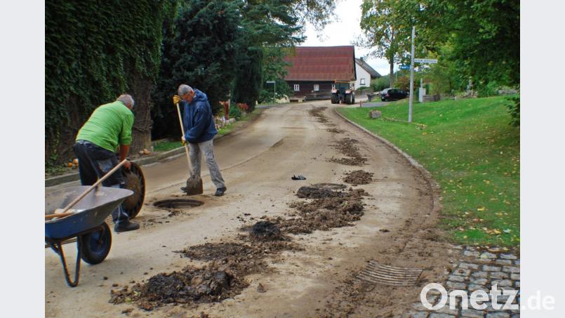Anwohner packen selbst mit an und reinigen die verstopften Gullys. Bild: enz