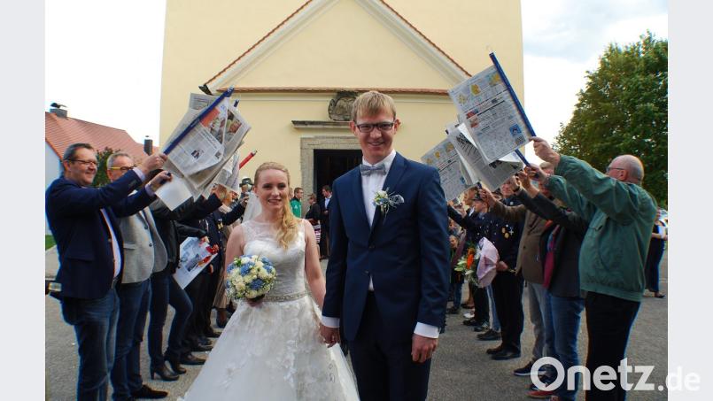 Franziska Bötzl und Martin Maier durchschreiten nach der Trauung ein langes Spalier Bild: enz