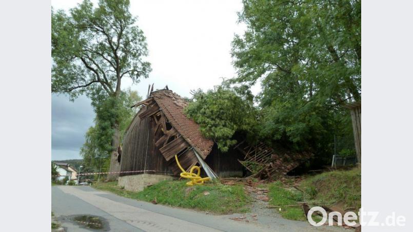 Das Sturmtief gab mächtig Gas: In Kühried (Gemeinde Teunz) krachte eine Scheune fast zusammen, nachdem ihr ein Ast einer mächtigen Eberesche (links) aufs Dach gefallen war. Die Straße war auch am Montagnachmittag noch abgesperrt. Bild: Portner