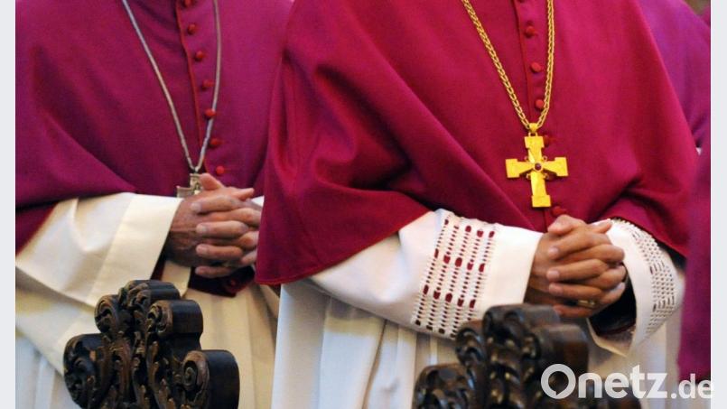 Mit gefaltetetn Händen ziehen die Bischöfe zum feierlichen Eröffnungsgottesdienst der Herbstvollversammlung in den Dom in Fulda ein. Bild: Uwe Zucchi/dpa