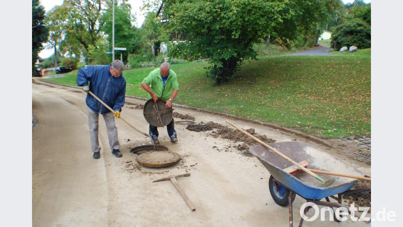 Anwohner packen selbst mit an und reinigen die verstopften Gullys. Bild: pz